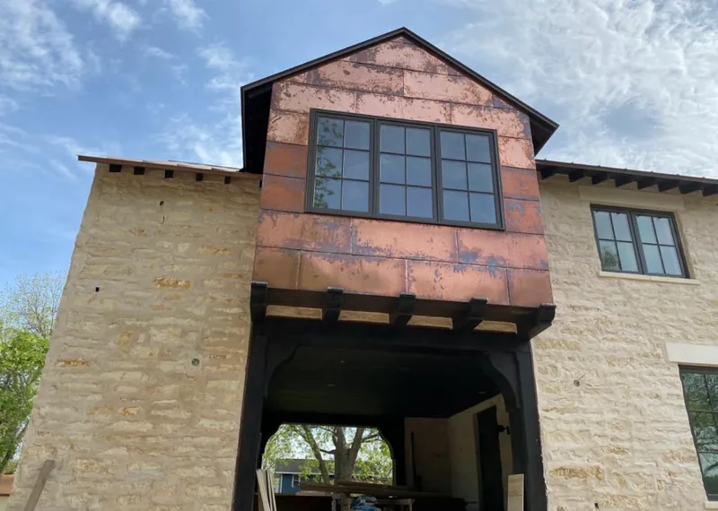 Copper metal panel facade on a stone building for Skylight Installation in River Ridge