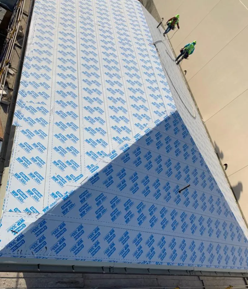 Professional roofers installing underlayment on a metal roof in River Ridge